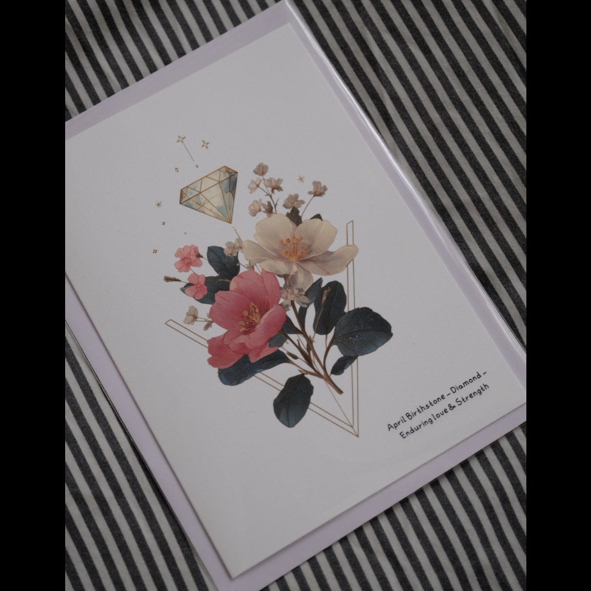 Card with floral design and geometric shapes on a striped background