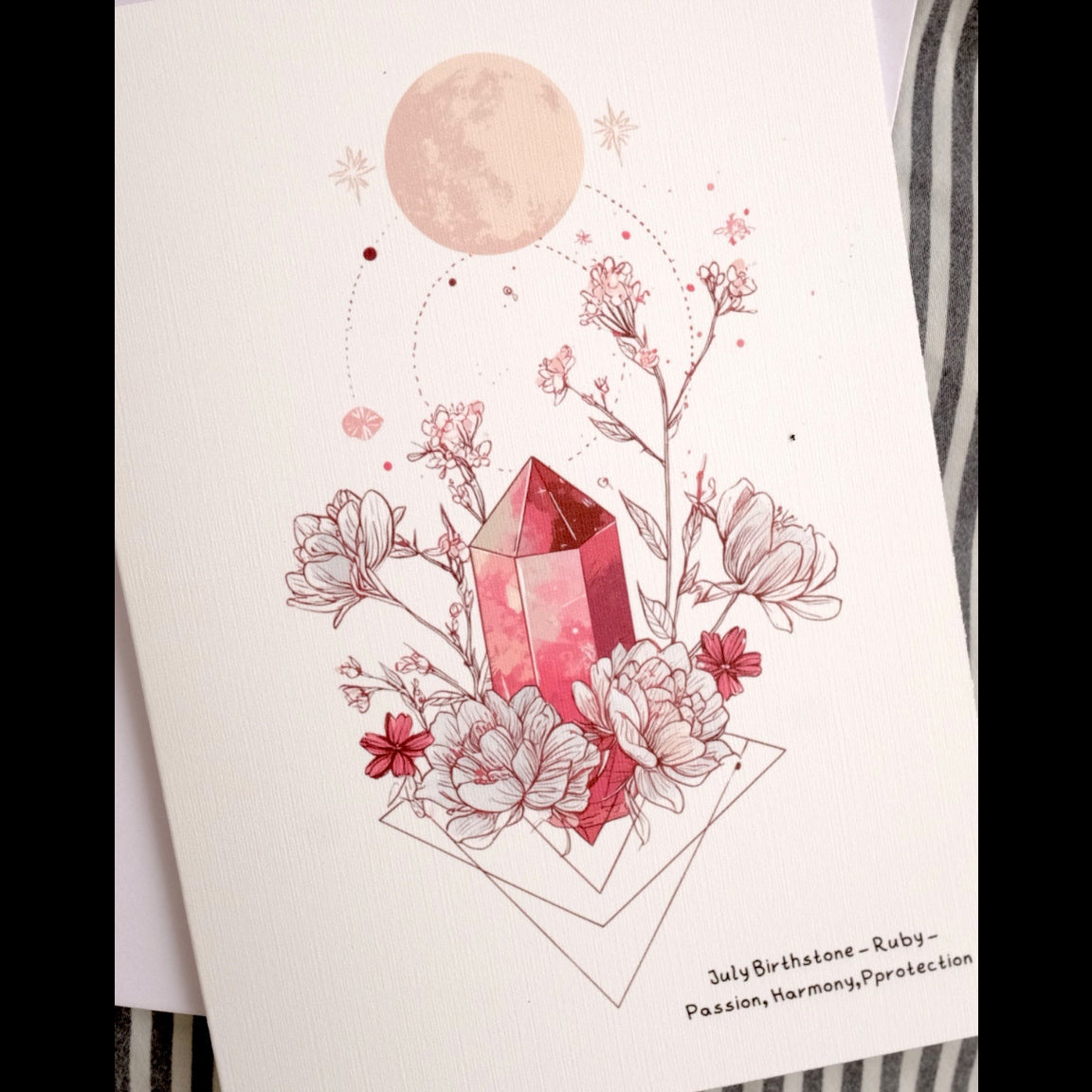 Greeting card with pink crystal and floral design on a striped background