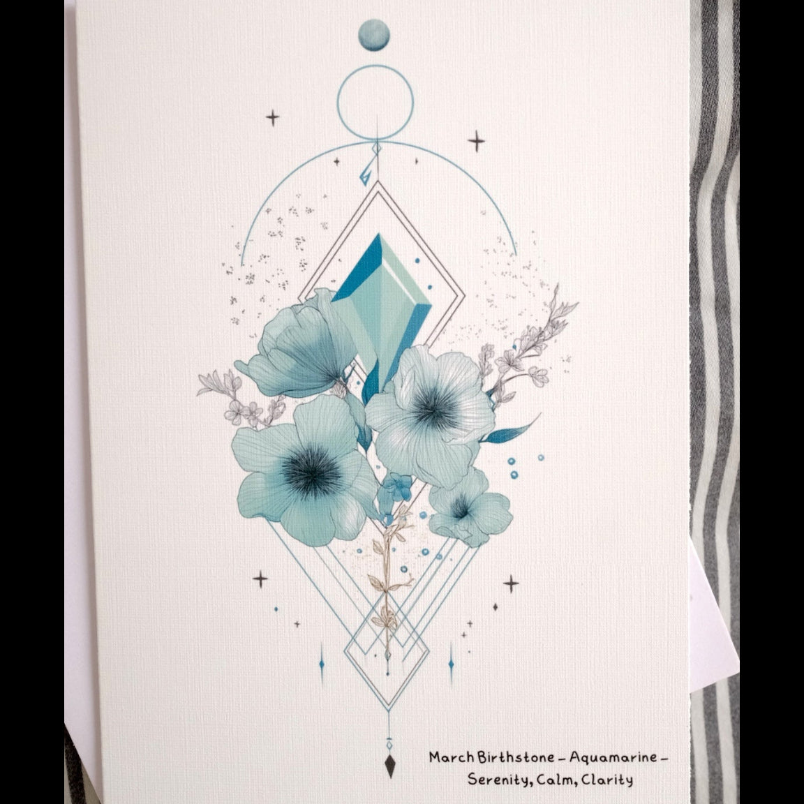 Card with blue floral design and geometric elements on a striped background